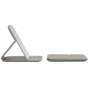 A folding mirror in a neutral grey colour with a sleek, portable design, featuring a stand and a flat base.