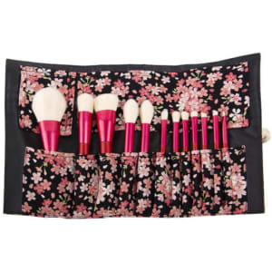 A 12-piece makeup brush set featuring a floral-patterned roll with pink handles and various brush styles.