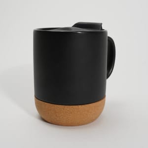 A black ceramic mug with a cork bottom, featuring a lid and a handle. It has a simple, modern design.