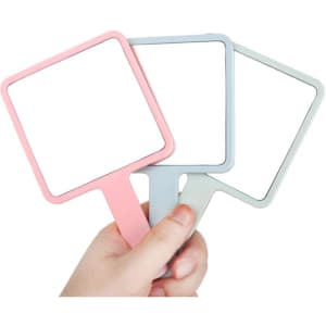 A collection of square-shaped handheld mirrors in pink, blue, and green, being held by a hand.