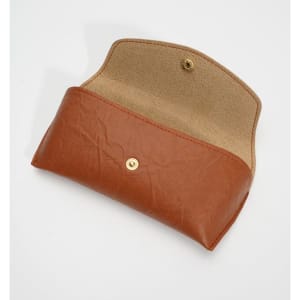 A brown sunglasses case with a button closure, featuring a soft interior lining. The case is opened, displaying its interior.
