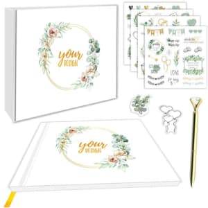 A wedding guest book set featuring a white cover with floral designs, stickers, and a gold pen.