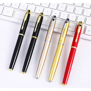 A ballpoint pen set featuring black, gold, silver, red, and a metallic pen, alongside a keyboard.