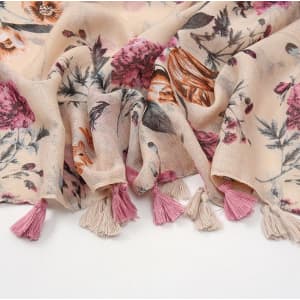 A floral cotton scarf featuring muted pink and cream tones with decorative tassels in pink and beige.