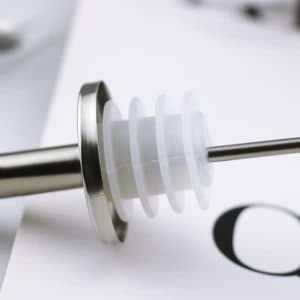 A stainless steel wine pourer spout with a white silicone stopper, featuring a metallic finish and a smooth design.