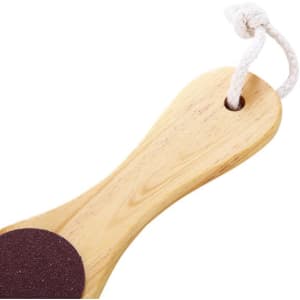 A foot file callus remover with a wooden handle and a dark abrasive surface, featuring a hanging loop.