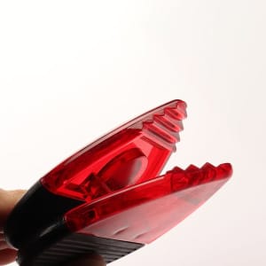 A red magnetic memo clip with a black handle, designed for holding notes or papers securely.
