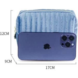 A pastel blue personalized makeup bag with a quilted design and a smartphone for size reference.