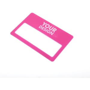 A pink credit card-shaped magnifier with a clear rectangular viewing area. It contains branding.