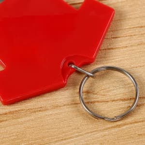 A drink bottle opener keychain in red, featuring a circular metal keyring attachment.