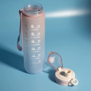 A drink bottle in pink and purple with a time scale, featuring a removable lid and a carrying strap.