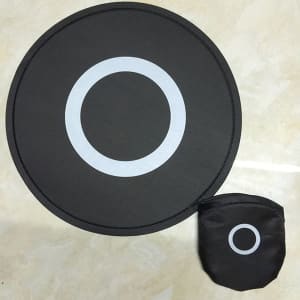 A black foldable flying disc fan with a circular design and a matching pouch, featuring a white circle pattern.