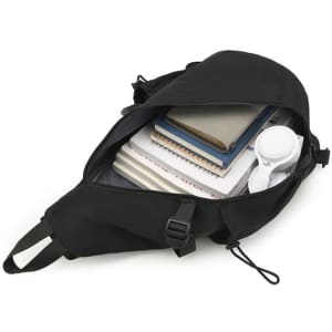A black casual crossbody sling bag filled with notebooks and a pair of headphones, featuring adjustable straps.