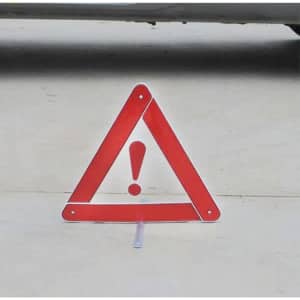 A triangular red warning sign with an exclamation mark, resting on a flat surface.