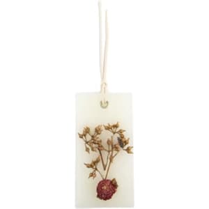 A dried flower scented wax tablet featuring a natural floral design on a pale background, with a hanging cord.