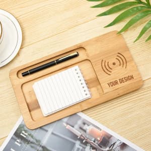 A bamboo desktop organiser featuring a wireless charging pad, a pen holder, and a notepad space.