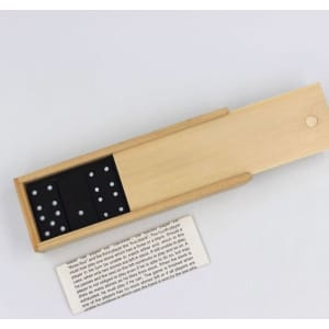 A wooden box containing a custom dominoes set with black domino pieces featuring white dots.