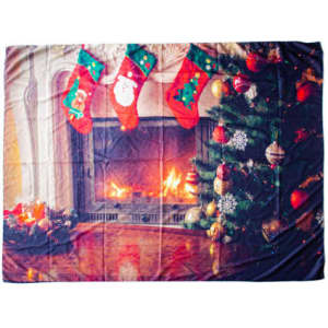 A decorative backdrop cloth featuring a festive scene with a fireplace, Christmas stockings, and a decorated tree, in vibrant colours.