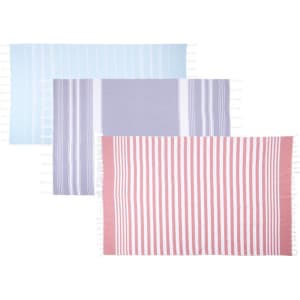 A set of three high-quality striped Turkish beach towels in blue, grey, and pink with fringed edges.