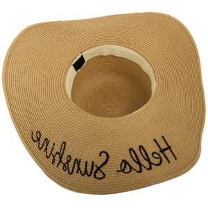 A wide brim straw hat in a tan colour with a black embroidered message. It features a logo inside.