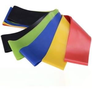 A set of resistance loop bands in red, yellow, green, blue, and black, arranged in a casual pile, including a carrying bag.