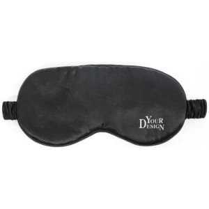 A black eye mask made of silk with elastic straps and a logo on one side.