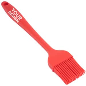 A red heat resistant silicone pastry brush with a long handle, featuring a branding logo on the handle.