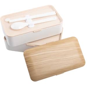 A wood grain double layer lunch box in beige and white, featuring utensils inside and a smooth, textured lid.