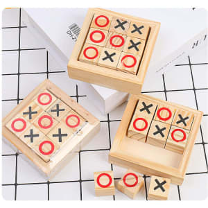 A wooden tic-tac-toe game featuring red circles and black crosses in a square box, set on a tiled surface.