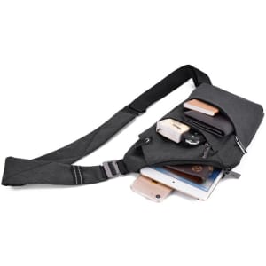 A grey crossbody sling bag with multiple compartments, featuring a strap, and containing a phone, wallet, and other items.