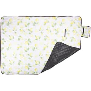 A floral-patterned picnic blanket with a black underside and a convenient carrying handle.