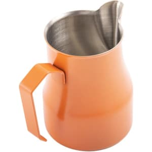 An orange stainless steel milk frothing pitcher with a curved spout and a sturdy handle. It has a branding logo.