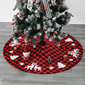 A Christmas tree skirt in red and black checkered pattern, featuring white snowflakes and festive motifs.