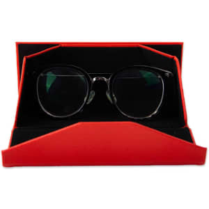 A foldable glasses case in red with a black interior, holding a pair of stylish round glasses.