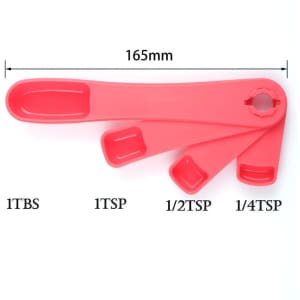 Four red plastic measuring spoons arranged on a white background, including sizes 1 tbsp, 1 tsp, ½ tsp, and ¼ tsp.