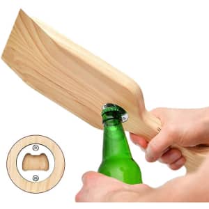A wooden BBQ grill scraper in a light colour with a bottle opener attached to the side.