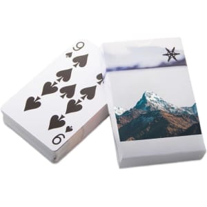 A deck of playing cards featuring a design with spades and a mountain scene on the box. The cards have a white background.