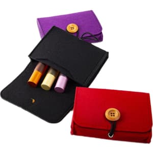 A black, purple, and red felt pouch with a button closure, containing essential oil bottles in various shades.