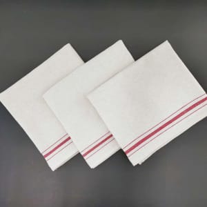 Three cream coloured cotton tea towels with a red stripe design laid out neatly on a dark surface.