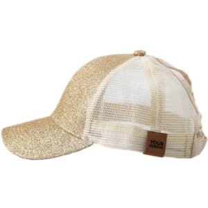 A glittery gold trucker cap with a mesh back and a branding label on the side.