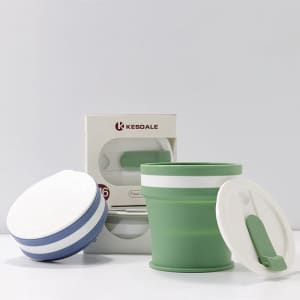A drink bottle featuring a green silicone collapsible travel mug with a white lid and packaging in the background.