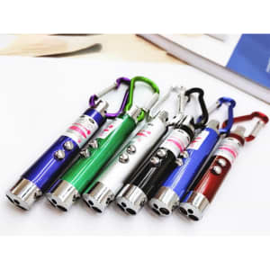 A collection of LED laser pen pointers in various colours: purple, green, white, black, red, and blue, with carabiner clips.