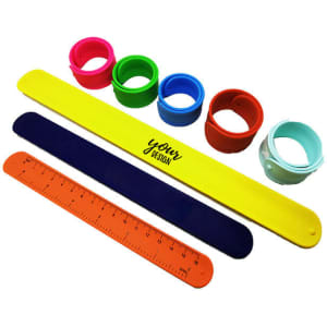 A variety of silicone slap bracelets in yellow, blue, green, red, orange, and light blue, featuring a design and ruler.