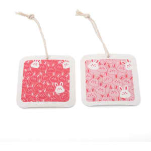 Two square coasters with a pink bunny pattern, featuring a twine loop for hanging. One coaster has a solid pink background, while the other has a repeated bunny design.