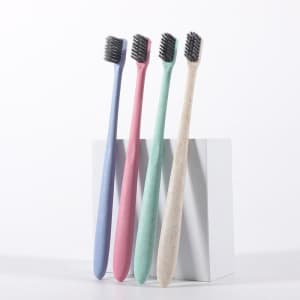 Four eco-friendly wheat straw soft toothbrushes in pastel colours: purple, pink, mint green, and natural beige, displayed together.