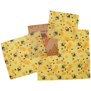 A set of three beeswax food wraps in yellow featuring bee and honeycomb patterns, with a branded sticker included.