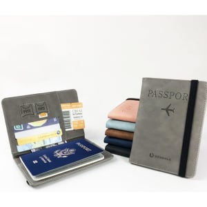 A grey PU leather passport holder with strap, featuring slots for cards and tickets, alongside various coloured holders.