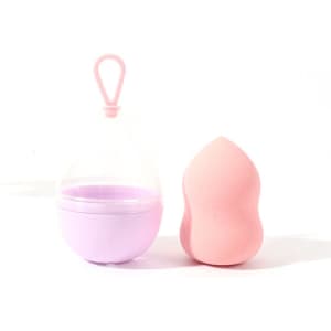 A pink gourd makeup sponge next to a transparent lanyard case with a purple base. The case has a loop for hanging.