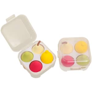 A clear case containing four fruit-shaped beauty sponges in green, yellow, pink, and red.