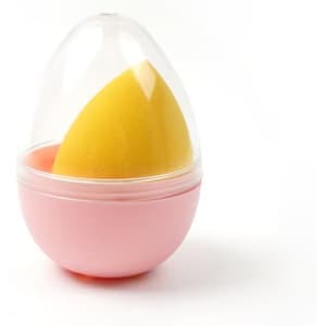 A pink case containing a yellow beauty sponge, shaped like an egg with a transparent lid.
